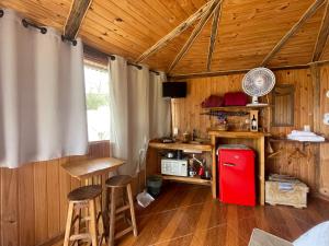 a room with a red refrigerator and wooden walls at Chalé Madeira Rústica in Visconde De Maua