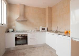 a kitchen with white cabinets and a microwave at Apartment Mirland Barcelona in Barcelona