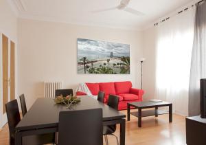 a living room with a red couch and a table at Apartment Mirland Barcelona in Barcelona