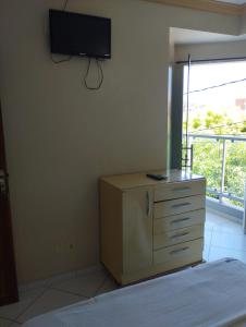 Pokój z komodą i telewizorem na ścianie w obiekcie Hotel Algaroba Anexo w mieście Bom Jesus da Lapa