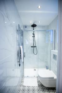 a white bathroom with a shower and a toilet at SO-LUX in Belfast