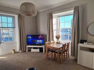 een woonkamer met een tafel en een televisie bij Ocean View in Campbeltown