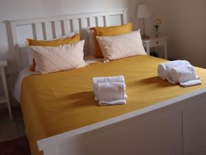 a large bed with two towels on top of it at Sunflower Guest House - Pico in São Caetano