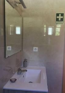 a bathroom with a white sink and a mirror at Sunflower Guest House - Pico in São Caetano