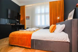 a bedroom with a bed with an orange blanket at Once apartments in Ivano-Frankivsʼk
