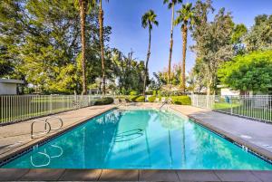 a swimming pool with a fence and palm trees at Cathedral City Gem 6 Mi to Downtown Palm Springs! in Cathedral City