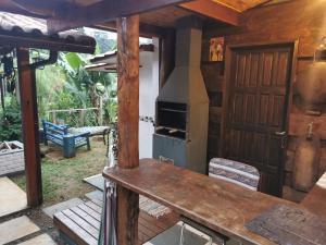 an outdoor kitchen with a stove and a door at Chalé Mauá Conforto e Arte in Visconde De Maua