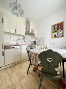 a kitchen with a table and a kitchen with white cabinets at 3 Zimmer Apart Bergblick in Kurort Oberwiesenthal