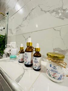 - un lavabo dans la salle de bains avec 3 bouteilles d'huile pour cheveux dans l'établissement West Bank luxury villa, à Louxor