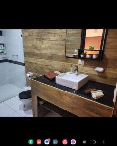 ein Badezimmer mit einem Waschbecken, einem WC und einem Spiegel in der Unterkunft CUENCA hermosa casa en el campo in Guishil