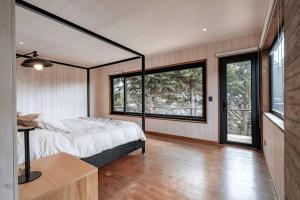 a bedroom with a bed and large windows at Punta Lobos Beachfront House, Taivarua in Pichilemu