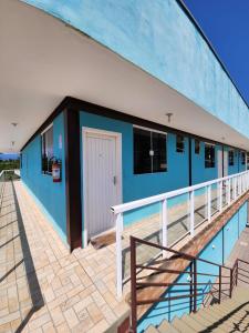 un edificio azul y blanco con balcón en Hospedaria Ilhabela - Flats Sul, en Ilhabela