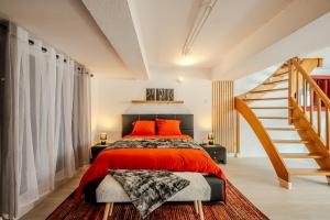 1 dormitorio con 1 cama con almohadas de color naranja y escalera en Cocon Relax - Cinéma - Les Cocons de Nath, en Montbéliard