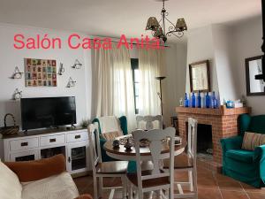- un salon avec une télévision, une table et des chaises dans l'établissement Casa Rural Paz, à Benarrabá