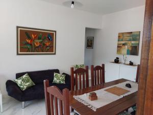 a dining room with a table and a couch at +A apartamentos in São Sebastião