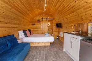 a room with a bed in a wooden cabin at Little Meadow Pods with Hot Tub in York