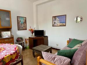 sala de estar con sofá y TV en Il Melograno, en Badesi