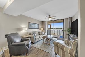 een woonkamer met een bank en een tv bij Compass Point Unit 208 in Gulf Shores