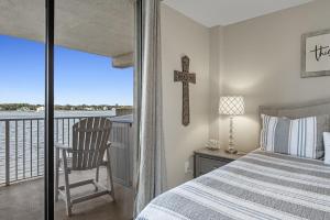 een slaapkamer met een bed en een kruis aan de muur bij Compass Point Unit 208 in Gulf Shores