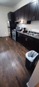 a kitchen with black cabinets and a wooden floor at Willoughby in Newark