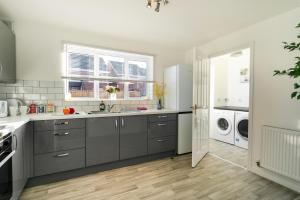 a kitchen with gray cabinets and a washer and dryer at * Parking * Sleeps 6 * Fast Wi-FI in Waddington