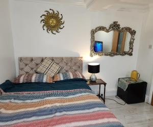 um quarto com uma cama e um espelho na parede em Ensuit Room in Solihull Town Centre em Solihull
