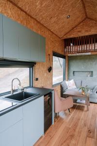 a kitchen with a sink and a living room at Hilltop Off Grid Tiny House with Outdoor Bath 