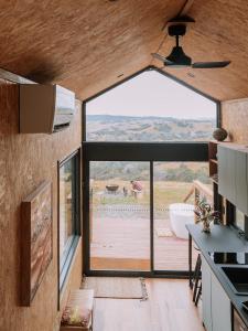 a kitchen with a large window in a tiny house at Hilltop Off Grid Tiny House with Outdoor Bath 