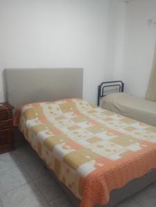 ein Bett in einem Zimmer mit einer Decke darauf in der Unterkunft Apart Belgrano in Corrientes