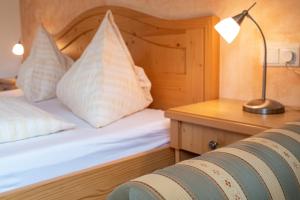 um quarto com uma cama e uma secretária com um candeeiro em Messnerhof, Durnholz em Valdurna