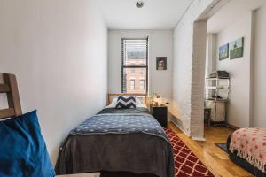 een kleine slaapkamer met een bed en een raam bij East Village Townhouse in New York