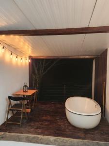 a room with a bath tub and a table and a table at Suítes Domo do Matto in Garanhuns