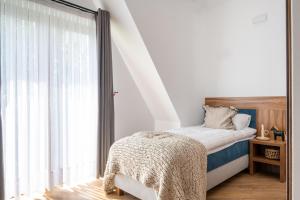 a bedroom with a bed and a large window at Para Apartments in Biały Dunajec