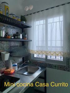 une cuisine avec un évier et une fenêtre dans l'établissement Casa Rural Paz, à Benarrabá
