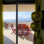 Una ventana con vistas a una habitación con mesa y sillas. en Benidorm Skyline, en Benidorm