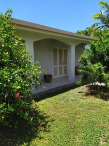 a small house with a porch and a yard at À 15’ de Poe Belle Villa in Bourail