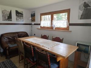 a dining room with a wooden table and chairs at Domek kempingowy w Kirach in Kościelisko