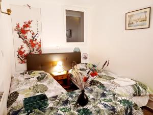 ein Schlafzimmer mit 2 Betten und einem Tisch mit einer Vase in der Unterkunft 3 private rooms shared flat in a villa at Sceaux 600m RER B direct to Notre-Dame in Sceaux