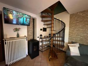 a living room with a spiral staircase and a stair case at La Casa del Mastro - Como Lake in Pognana Lario
