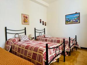 a bedroom with two beds and a tv on the wall at Il Melograno in Badesi