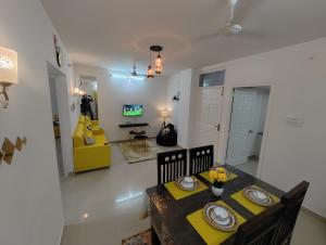a dining room with a table and a yellow chair at NK Homes - Serviced Apartments in Hyderabad