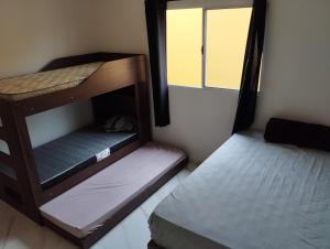 2 Etagenbetten in einem Zimmer mit Fenster in der Unterkunft LOCAMAR in Itanhaém