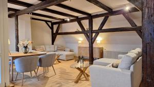 a living room with exposed beams and a table and chairs at Stadtpalais Bellevue-Suite 3- Zimmer- Maisonettewohnung mit Dachterrasse maximal 4 Personen in Bautzen