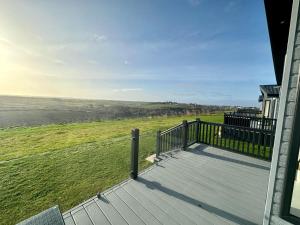 uma varanda de uma casa com vista para um campo em Luxury 3 bedroom Maple View Lodge, Newquay, Cornwall em Newquay