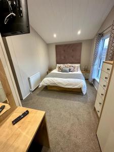 a bedroom with a bed and a television in it at Luxury 3 bedroom Maple View Lodge, Newquay, Cornwall in Newquay