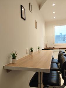 una sala de conferencias con mesa de madera y sillas en Le Beau Refuge Parisien de Cergy - Parisian modern flat at Cergy, en Cergy