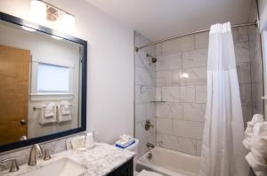 W łazience znajduje się wanna, umywalka i prysznic. w obiekcie Anchorage Motel w mieście Bar Harbor