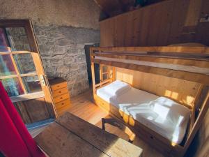 a room with two bunk beds and a table at Appartement cosy avec jardin in Saint-Jean-d'Aulps