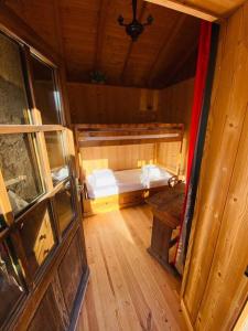 mały pokój z łóżkiem i drewnianą podłogą w obiekcie Appartement cosy avec jardin w mieście Saint-Jean-dʼAulps