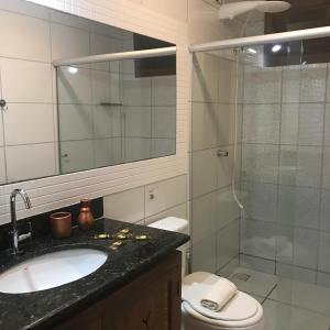 een badkamer met een wastafel, een toilet en een douche bij Bahia Bonita Flat in Itacaré